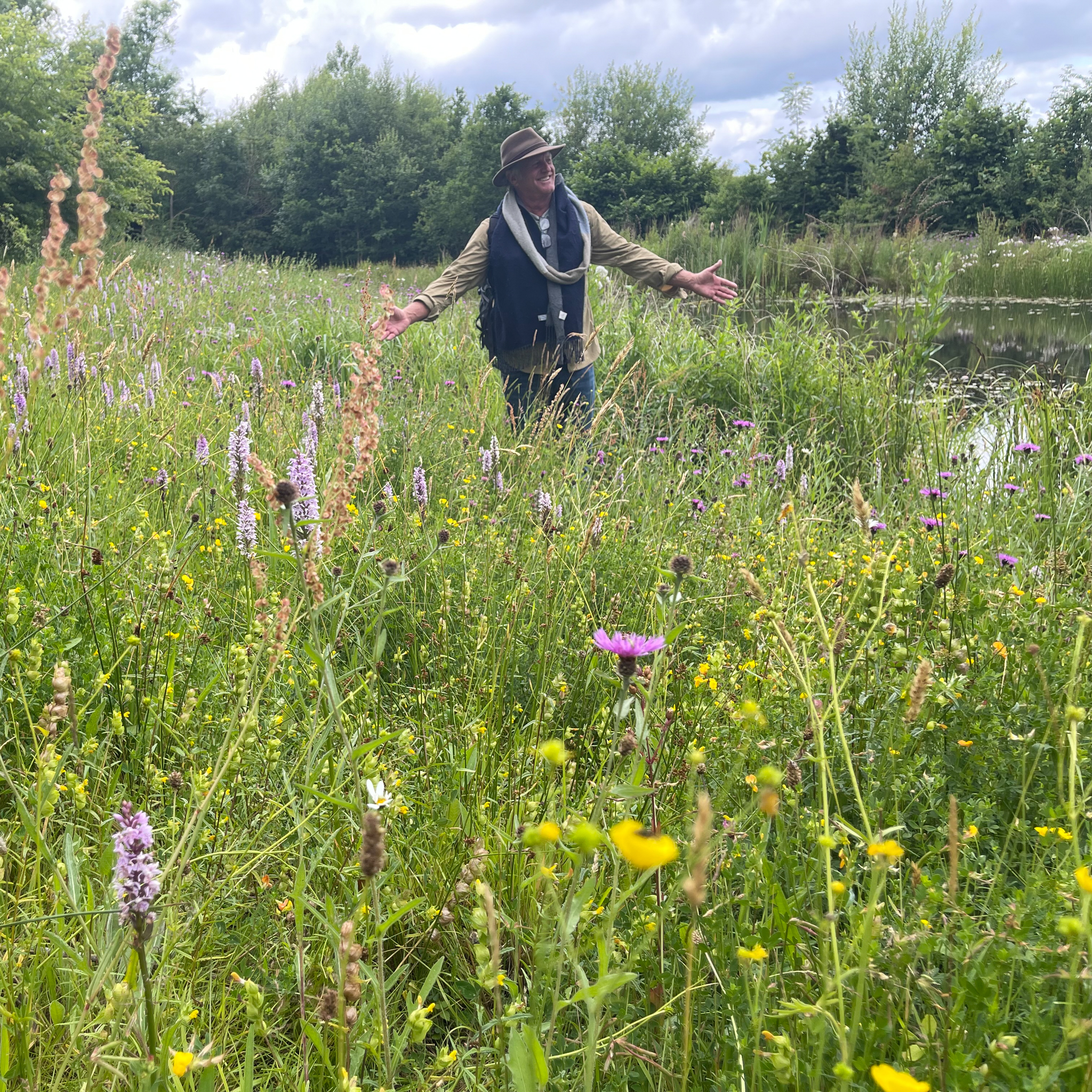 John Greenlee among a tall wild-like meadow.